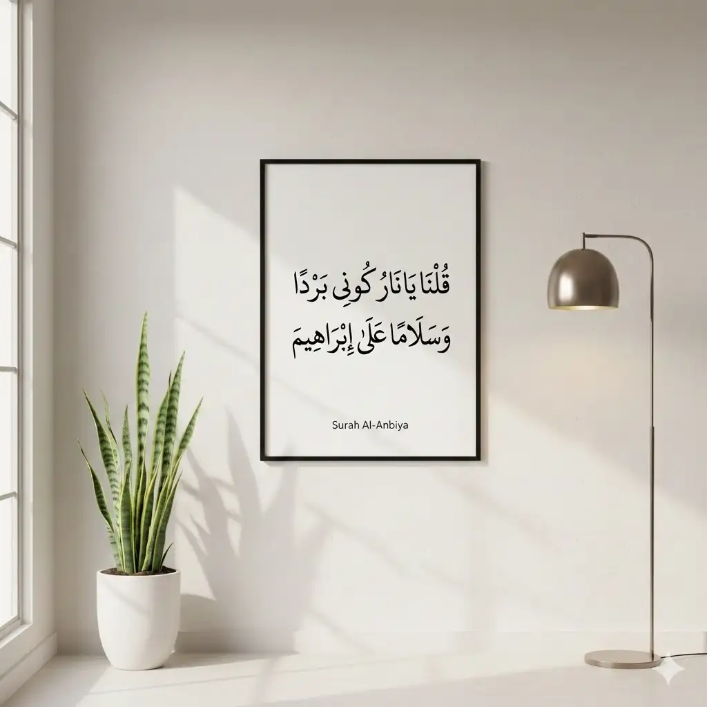 Elegant Arabic calligraphy of Surah Al-Anbiya Verse 69 "Ya Naru Kuni Bardan" in a modern black frame on a minimalist wall.